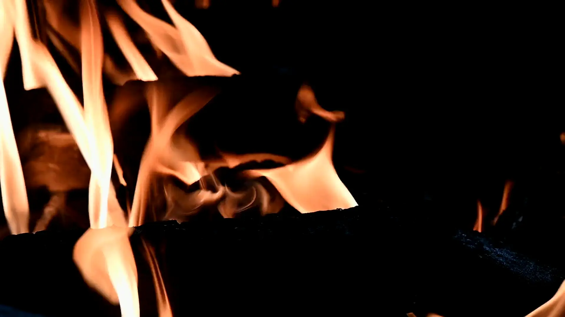 Glühende Holzkohle mit Flammen und Funkenflug im Glutwerk-Grill